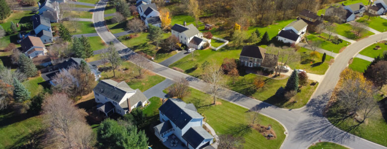 Low density single family residential houses with grassy yards landscaping in established development neighborhood in Rochester, Upstate New York, USA. Aerial view two story home on large lot size